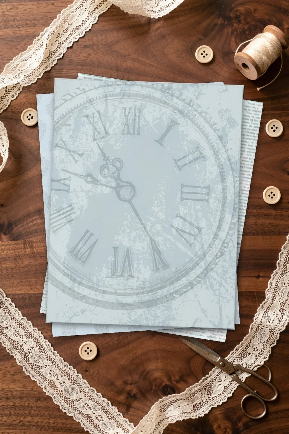 Pale blue vintage scrapbook paper with a clock face, printed sheets stacked, on a dark walnut table with lace, buttons and scissors